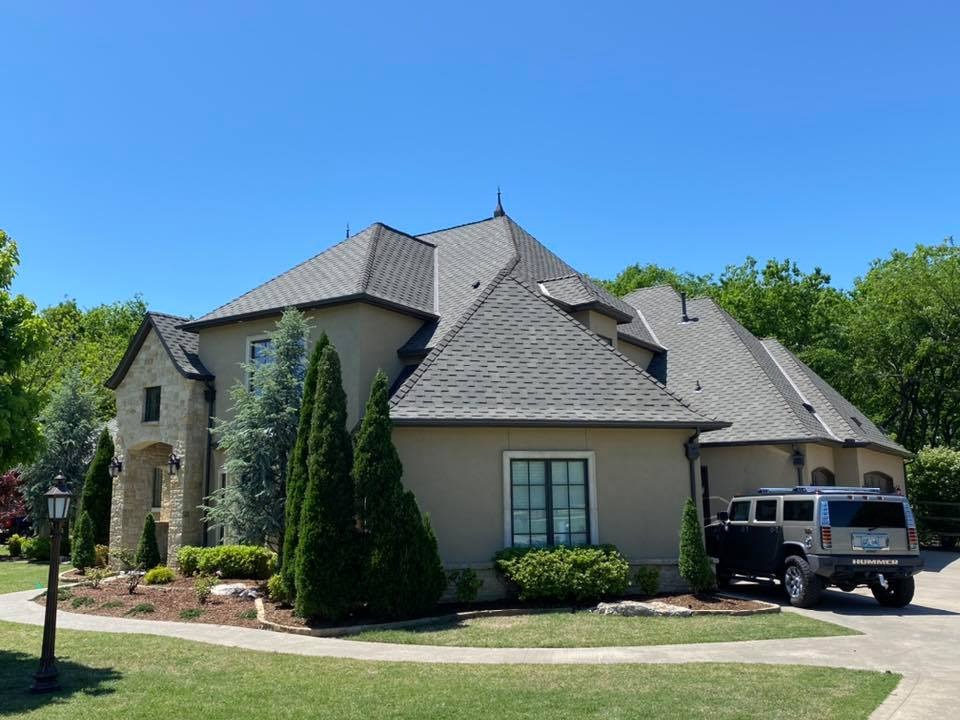 Large steep pitch residential roof with stone accents