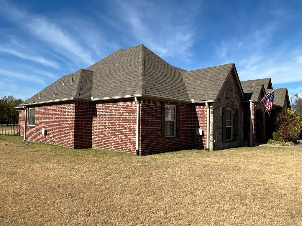 Newly installed architectural shingle roof on a large brick home