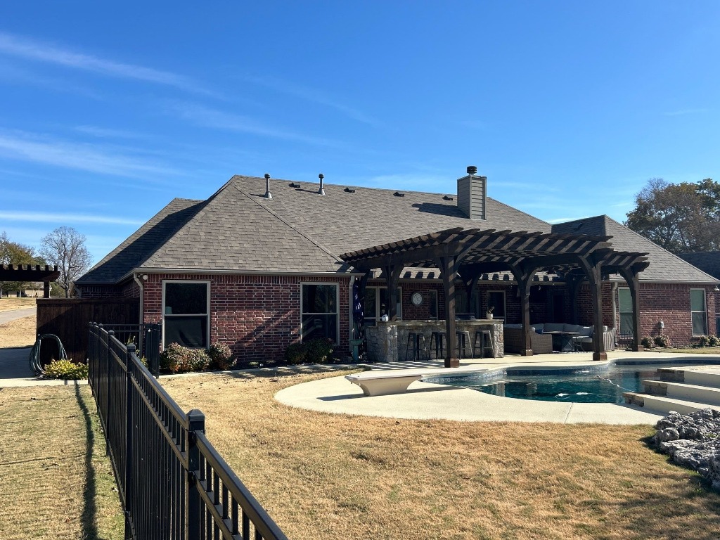 Backyard view of a new roof protecting a pergola and pool area