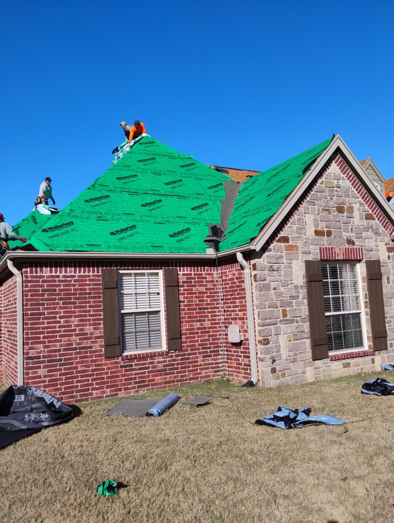 Crew installing green Malarkey Secure Choice underlayment